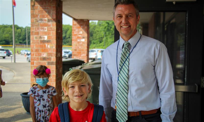 A student and administrator smile